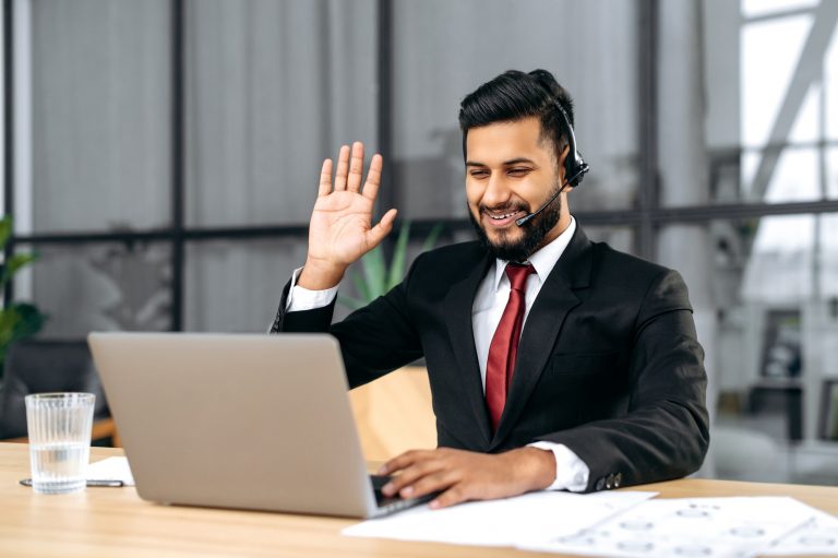 Positive successful indian or arabian man in suit, with headset, business advisor, call center