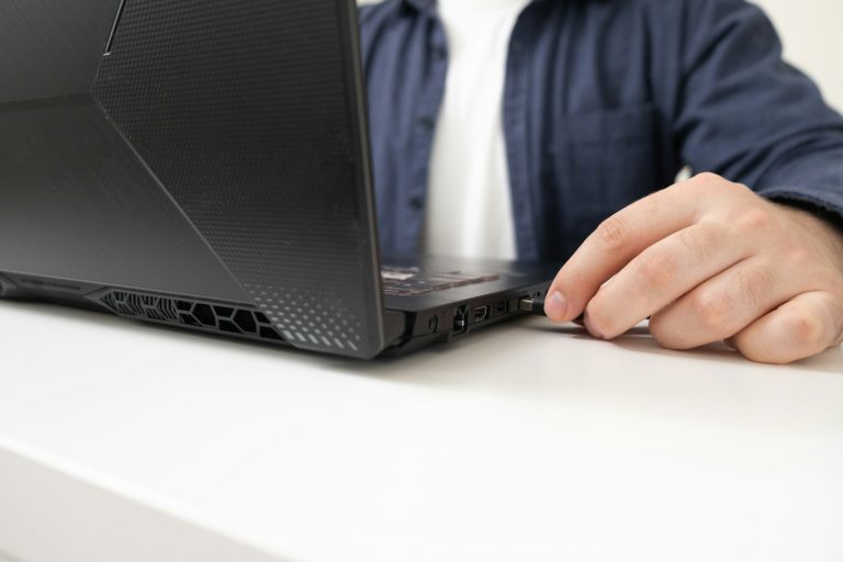 A man inserts a USB drive into his laptop